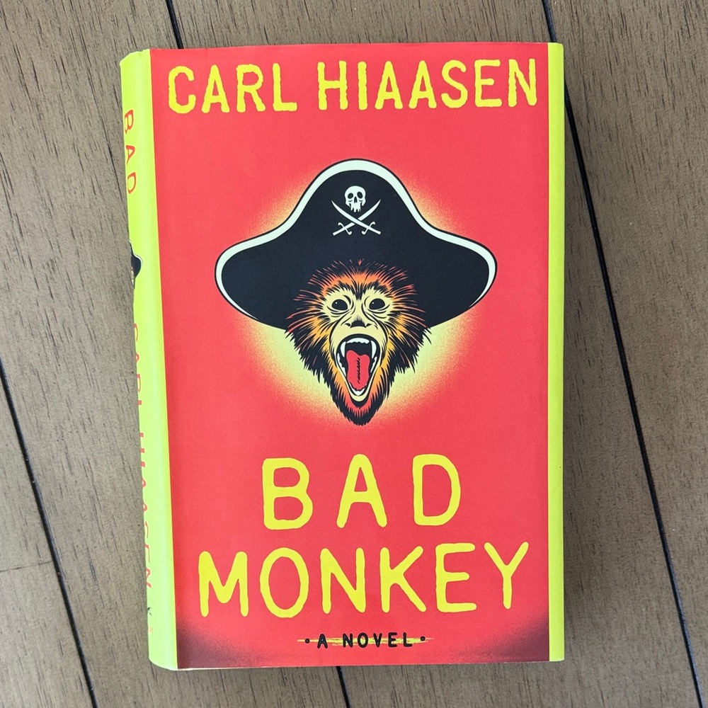 Carl Hiaasen "Bad Monkey" Hardcover Book - Bright Red & Neon Yellow Cover
